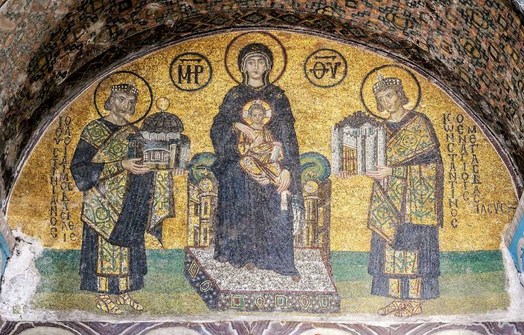 Mosaïque de l'entrée sud-ouest de l'ancienne basilique Sainte-Sophie de Constantinople . Au milieu, Marie tenant l'Enfant Jésus sur ses genoux. À sa droite, l'empereur Justinien, offrant un modèle de Sainte-Sophie. Sur sa gauche, l'empereur Constantin 1er offre une maquette de Constantinople.
